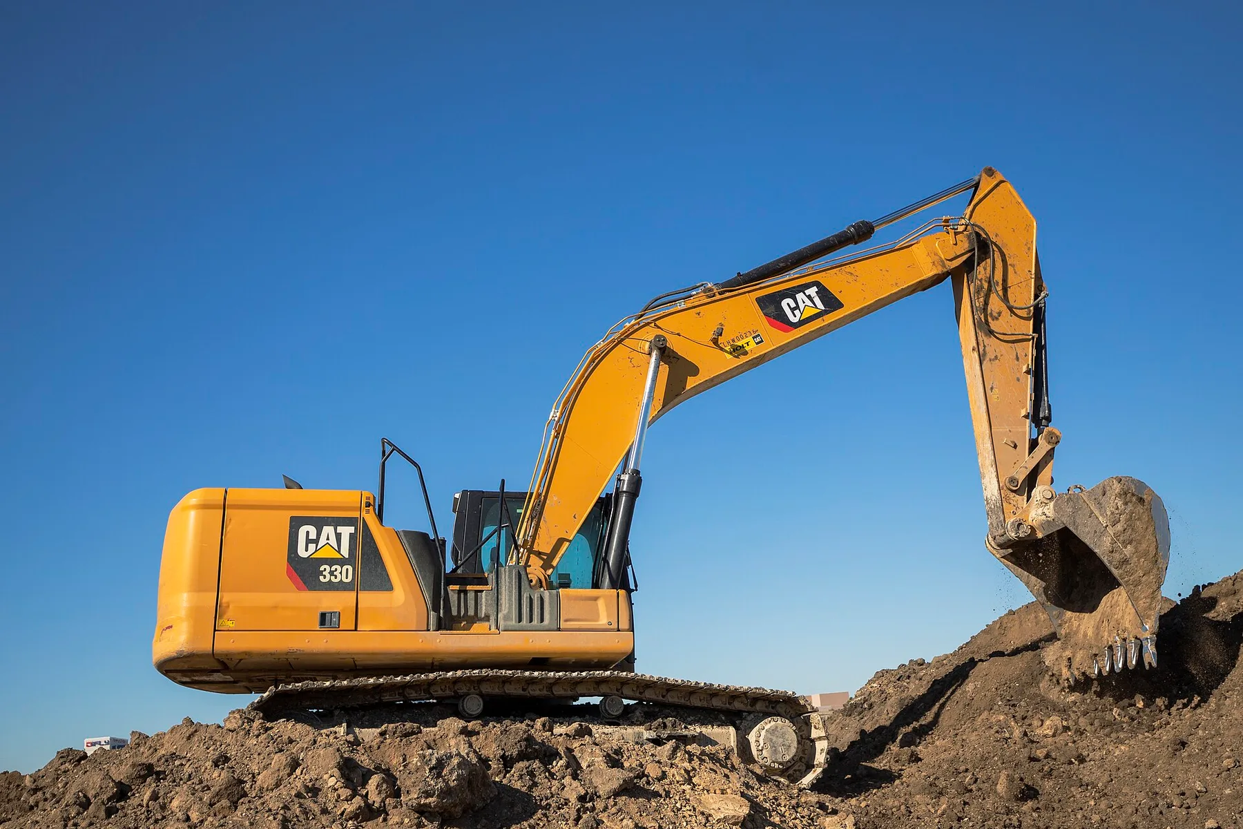 Caterpillar 330 hydraulic excavator digging on site — the kind of used machine SK inspects and documents before export